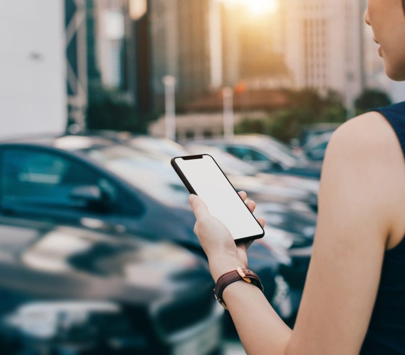 woman-using-smartphone-while-walking-to-her-car-in-royalty-free-image-1616451210_